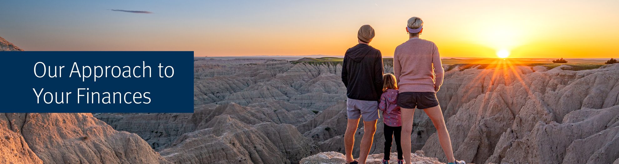 Mother, Father, and Daughter Enjoy a Vibrant Sunset Over the Beautiful Geological Rock Formations Around Pinnacles Overlook in Badlands National Park in South Dakota USA